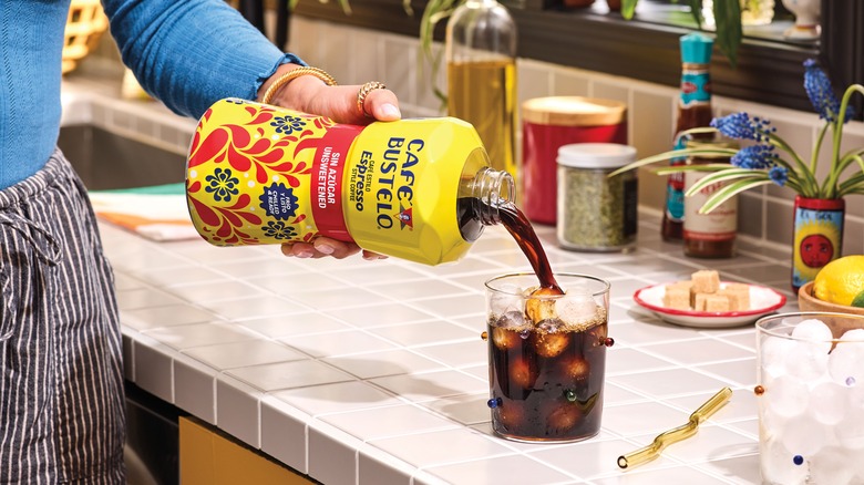 Hand pouring Café Bustelo coffee into a glass