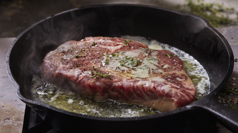 Steak cooking in cast iron skillet